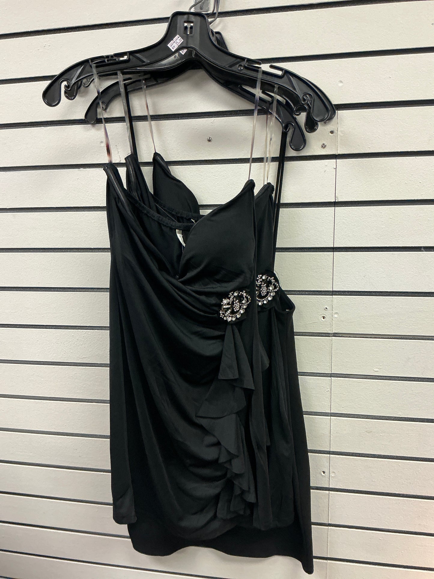 Elegant black dress with brooch on the side and ruffles
